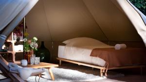 德瓦尔Eco Farm Camping 'de Waeldernis'的帐篷内的一张床位,配有桌子