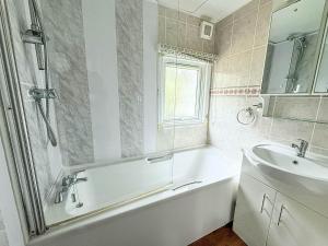 a white bathroom with a tub and a sink at Pet Friendly, Luxury Lodge With Decking In Suffolk Near The Beach Ref 32108A in Lowestoft +12 photos