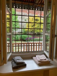 Dos toallas colocadas en el alféizar de una ventana frente a una ventana. en Palazzo Caroni, en Piasco