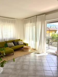 a living room with a green couch and a large window at Fortuna's quiet place in Riva del Garda