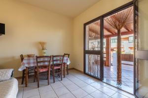 un salon avec une table et des chaises et une fenêtre dans l'établissement Via Delle Mimose 14, à Calasetta