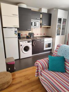 a living room with a couch and a kitchen at El apartamento de Fina in Gijón