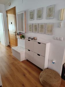 a room with a white dresser and some drawings on the wall at El apartamento de Fina in Gijón +7 photos