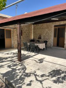 an outdoor patio with a table and chairs at Friendly villagehouse in Paphos