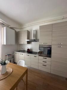 a kitchen with white cabinets and a wooden table at Casa Rovani in Sesto San Giovanni