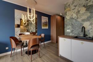 a kitchen and dining room with a table and chairs at RentPlanet - Apartamenty IzerSKI Resort in Świeradów-Zdrój