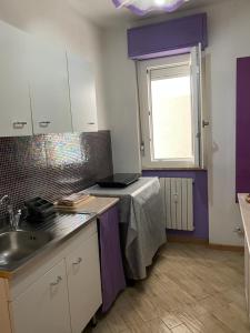 a kitchen with a table and a sink and a window at LA CASA DEL CAVALLO - The horse house in Sassari