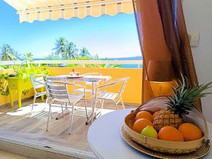a table with a basket of fruit on a balcony at Chez Marguerite by MAGCAR in Le Gosier