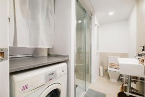 une salle de bains avec lave-linge et lavabo dans l'établissement Casa Jesús PS5 Juegos Niños WiFi 6 Pax, à Saragosse 66 autres photos
