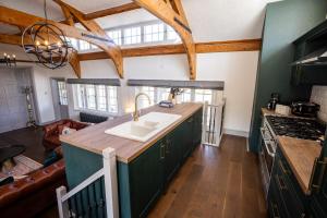 a kitchen with green cabinets and a sink at Greta Howe in Keswick