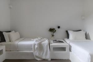 a white living room with a couch and a table at Acron Villas Paros in Kolympithres