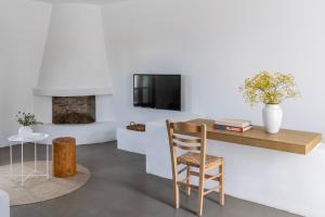 a room with a desk and a chair and a tv at Acron Villas Paros in Kolympithres