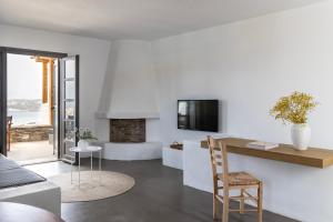 a living room with a table and a fireplace at Acron Villas Paros in Kolympithres