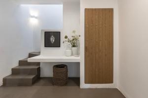 a room with a white table and a wooden door at Acron Villas Paros in Kolympithres