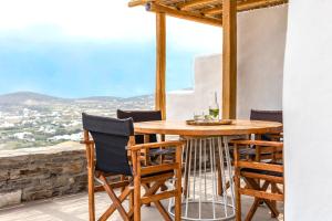 a table and chairs on a balcony with a view at Acron Villas Paros in Kolympithres