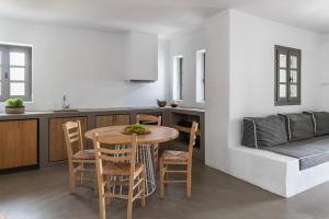 a kitchen and dining room with a table and chairs at Acron Villas Paros in Kolympithres