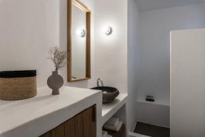 a bathroom with a sink and a mirror at Acron Villas Paros in Kolympithres