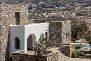 a villa with a swimming pool and a building at Acron Villas Paros in Kolympithres