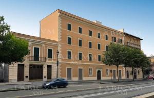 a car driving past a large building on a street at Labicum XXII - Modern Luxury Studio near the Colosseum in Rome