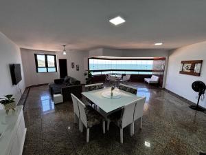 a living room with a table and a couch at Apartamento Espaçoso com Vista Fabulosa para o Mar in Guarapari +6 photos