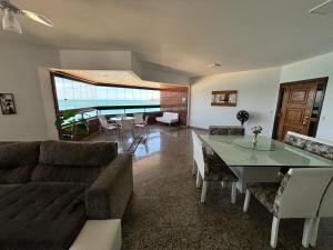 a living room with a couch and a table at Apartamento Espaçoso com Vista Fabulosa para o Mar in Guarapari