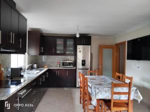a kitchen with a table and chairs and a kitchen with black cabinets at La Casa de Marta in Ribeira de Pena +16 photos