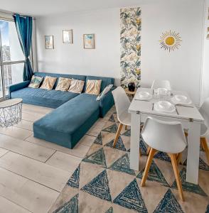 a living room with a blue couch and a table at Lumineux avec balcon & confort familial in Le Havre