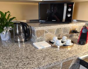 a kitchen counter with a microwave and cups on a tray at Casa di Elena in Mottella +12 photos
