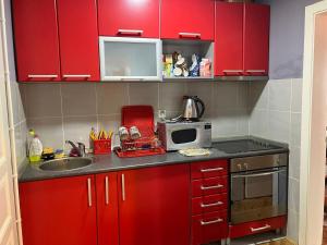a red kitchen with a sink and a microwave at Tanasic in Zlatibor