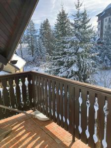 a balcony with snow covered trees and a fence at Tanasic in Zlatibor +11 photos