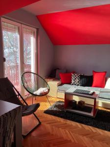 ein Wohnzimmer mit einer roten Decke und einem Sofa in der Unterkunft Tanasic in Zlatibor
