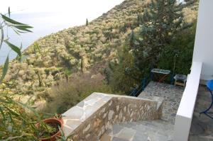 a stone staircase leading down to a hill with the water at Cottage in Tiros +6 photos