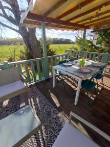 a table and chairs on a deck with a tree at Gorges du verdon Eden34 in Sainte-Croix-de-Verdon