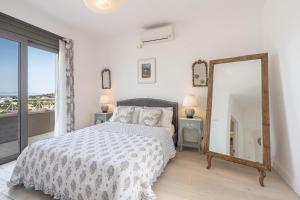 a bedroom with a bed and a mirror and a window at Tranquil house in Kipséli
