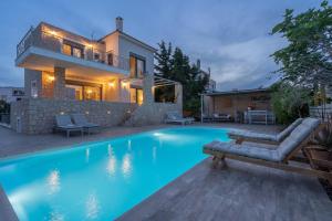 a villa with a swimming pool and a house at Tranquil house in Kipséli