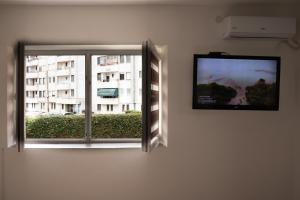 a flat screen tv on a wall next to a window at Iris Apartments in Ohrid