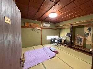 Rúm í herbergi á Guesthouse Hikari