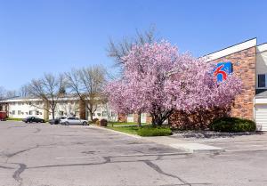 a tree with pink flowers in front of a building at Motel 6-Spokane, WA - East in Spokane Valley