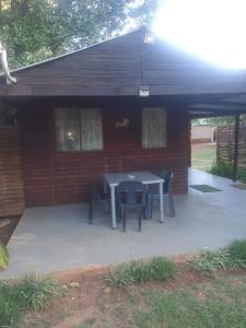 a patio with a table and chairs in front of a building at Chalet 6 At Cynthias Country in Hartbeespoort