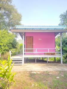 a pink house with a bench in front of it at บ้านสวนนกโฮมสเตย์ OWLHOUSE in Ban Pong Pat +7 photos