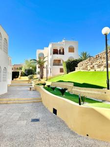 a view of a building with a green yard at Apartamento en Puerto de Mazarrón con piscina in Mazarrón
