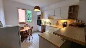 a kitchen with white cabinets and a wooden counter top at T3 La Vieille Distillerie, Petit-Bourg in Petit-Bourg