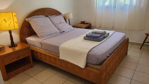 Un dormitorio con una cama con dos toallas encima. en T3 La Vieille Distillerie, Petit-Bourg, en Petit-Bourg 9 fotos más