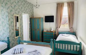 a bedroom with two beds and a tv in it at The Cobham Hotel in Southend-on-Sea