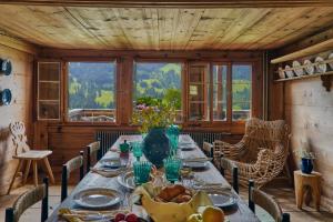 a dining room with a table with food on it at Le Chalet Lion Rouge in Rougemont
