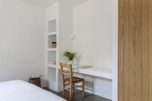 a bedroom with a desk and a chair next to a bed at Acron Villas Paros in Kolympithres