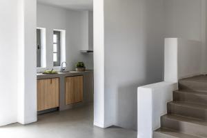 a kitchen with a sink and a staircase in a room at Acron Villas Paros in Kolympithres