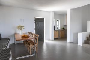 a kitchen and dining room with a table and chairs at Acron Villas Paros in Kolympithres