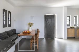 a living room with a table and a couch at Acron Villas Paros in Kolympithres