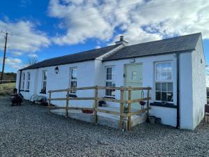 a white house with a wooden fence in front of it at Terry Joe Cottages in Newry
